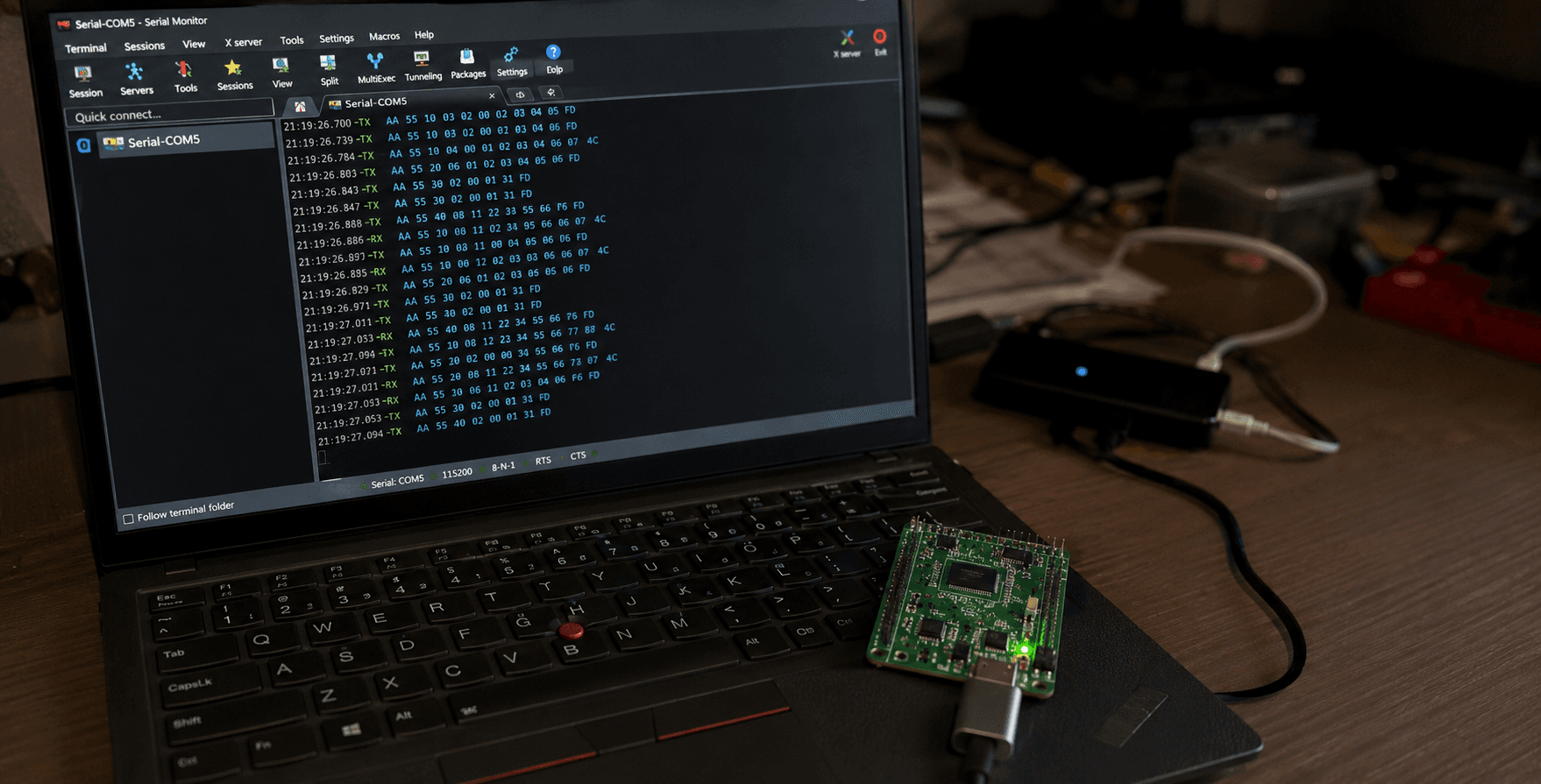 Messy tech workstation with serial monitor